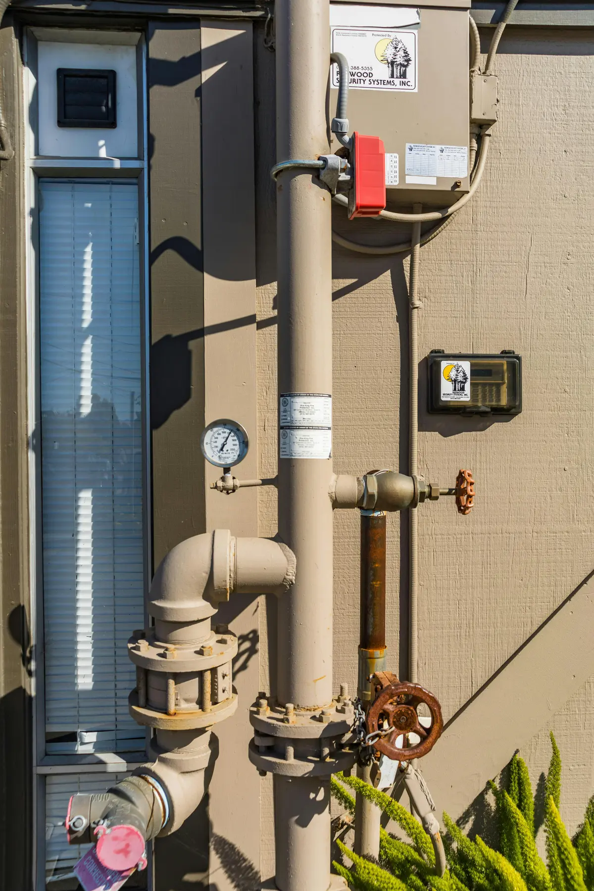 Exterior backflow preventer with pressure gauge and piping
