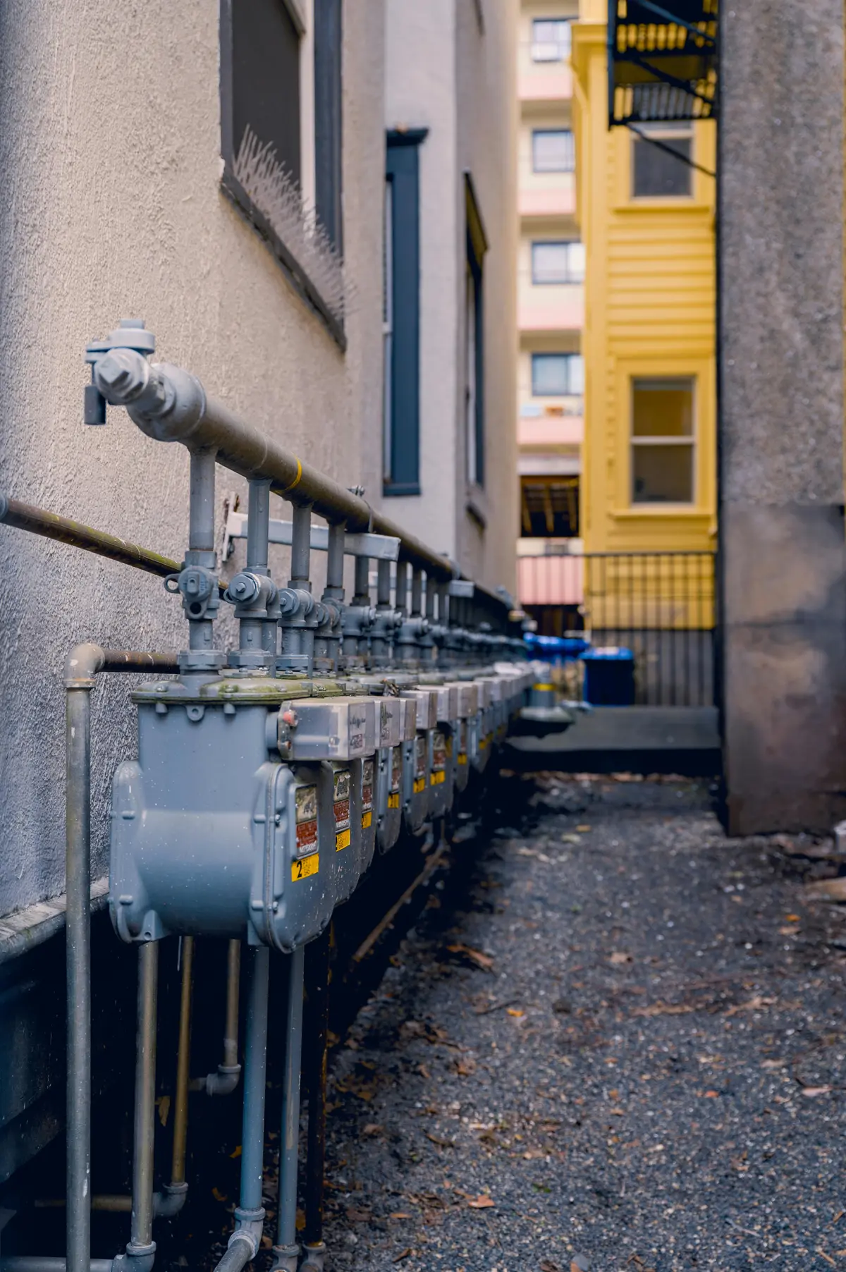 Row of gas meters and supply lines on building exterior